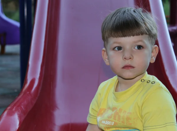 Little boy standing on slide — Stock Photo, Image