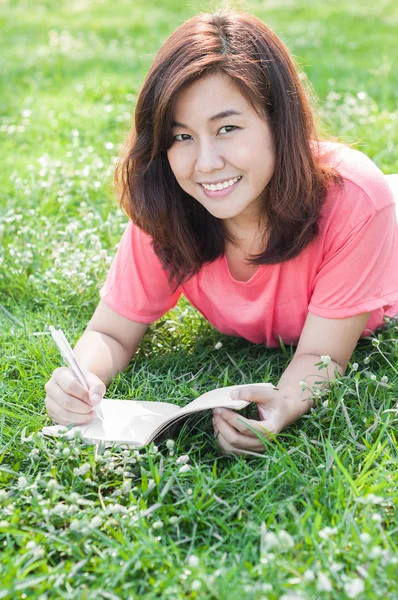 Happy Young Asian Woman Writing in Notebook and Smiling — Stock Photo, Image