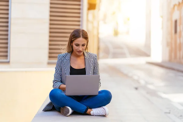 Mujer concentrada trabajando en el portátil en la calle — Foto de Stock