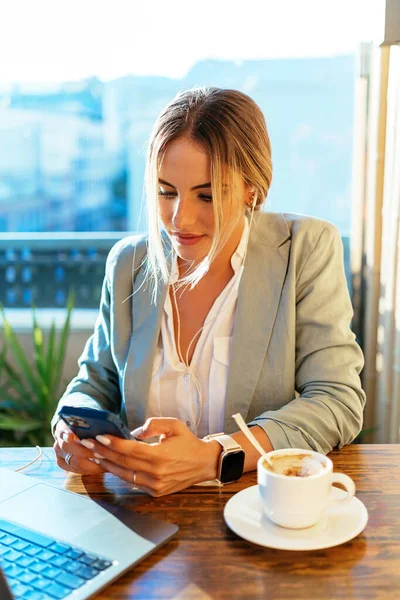 Mujer de negocios navegando teléfono inteligente en la cafetería — Foto de Stock