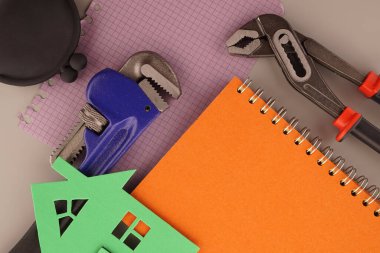 Ev inşaatı, inşaat ya da mülkiyet düz dizüstü bilgisayarlar, anahtar, çanta ve renkli kağıt evlerle dolu natürmort yaşam konsepti