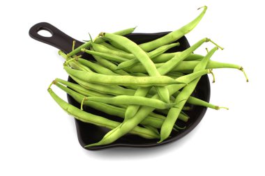 Pişirme tavasındaki bir avuç yeşil fasulye beyaz arka planda izole edilmiş. Sağlıklı, besleyici vejetaryen yiyecekler.