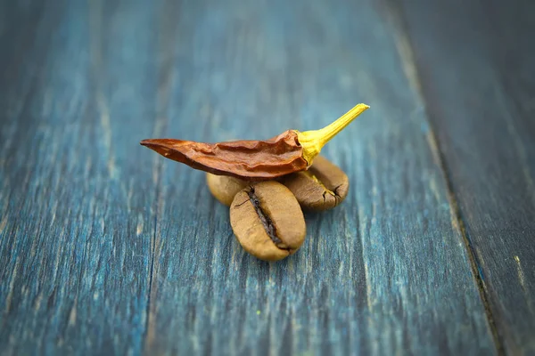 焙煎したコーヒー豆と木の背景に赤唐辛子を乾燥させました マクロ写真 — ストック写真