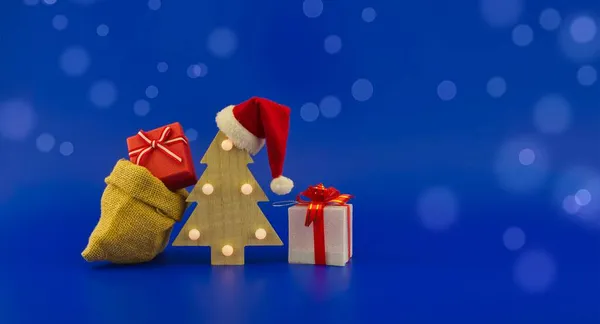 Різдвяна Ялинка Червоним Капелюхом Санти Джутовим Мішком Подарунковими Коробками Святковому — стокове фото