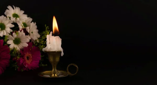 Short White Candle Burning Floor Close Flowers Dark Background — Stock Photo, Image