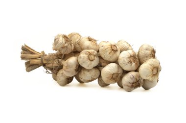 Örülmüş sarımsak soğanları jüt halatla bağlanmış beyaz arka planda saklanmaya hazır.