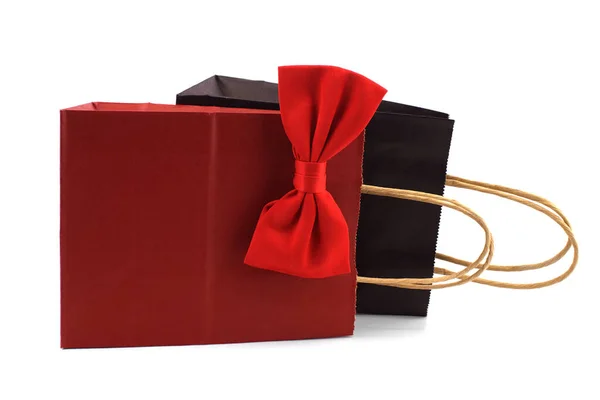 白い背景に赤い蝶ネクタイの黒と赤の紙のショッピングバッグ 紳士やショッピングのコンセプトへの贈り物 — ストック写真