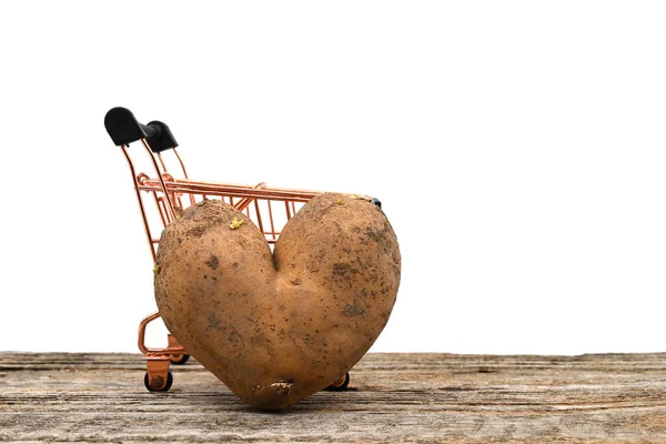 Kalp Şeklindeki Patatesler Beyaz Bir Masanın Üzerinde Bir Alışveriş Arabasına — Stok fotoğraf