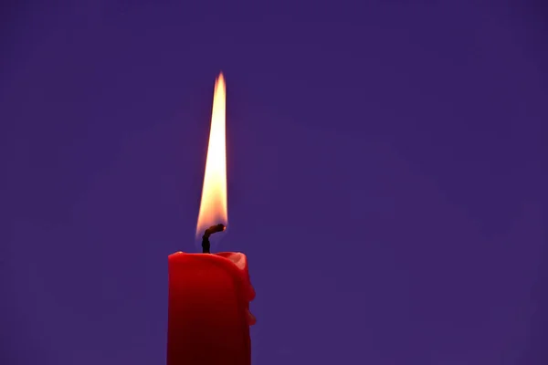 Close Uma Vela Vermelha Acesa Contra Fundo Violeta Luz Vela — Fotografia de Stock