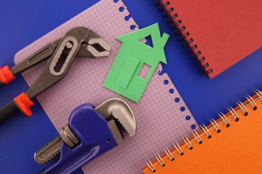 Ev sahipliği, inşaat ya da inşaat düz defter, anahtar, cüzdan, kalem ve renkli kağıt evlerle dolu bir yaşam konsepti