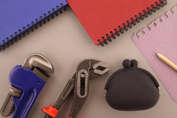Renovation, production, manufacturing, building or repairs flat lay concept with an arrangement of two assorted wrenches and note books in a blue and red theme