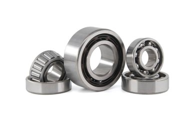 Beyaz arka planda çeşitli bilye ve bilye setleri. Motor ve şasi süspansiyonu için otomobil parçaları, otomobil parçaları.