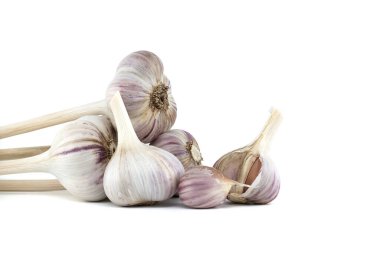 Beyaz arka planda taze toplanmış sarımsak soğanları ve karanfiller.