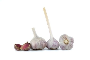 Beyaz arka planda taze toplanmış sarımsak soğanları ve karanfiller.