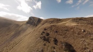 FPV insansız hava aracı görüntüleri: Düzleştirilmiş Sinek Highland Gölü etrafındaki Rocky Tepesi boyunca uçuyor.