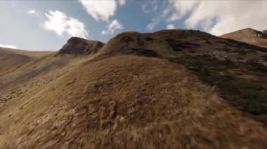 FPV insansız hava aracı görüntüleri: Düzleştirilmiş Sinek Highland Gölü etrafındaki Rocky Tepesi boyunca uçuyor.