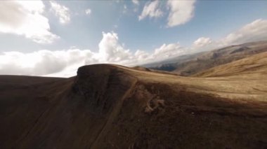 FPV insansız hava aracı görüntüleri: Düzleştirilmiş Sinek Highland Gölü etrafındaki Rocky Tepesi boyunca uçuyor.