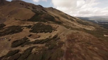 FPV insansız hava aracı görüntüleri: Düzleştirilmiş Sinek Highland Gölü etrafındaki Rocky Tepesi boyunca uçuyor.