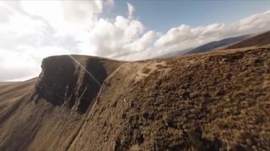 FPV insansız hava aracı görüntüleri: Düzleştirilmiş Sinek Highland Gölü etrafındaki Rocky Tepesi boyunca uçuyor.