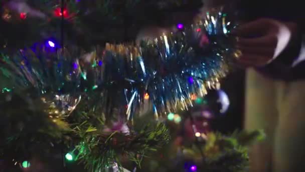 Slow Motion: Le giovani ragazze caucasiche mettono le decorazioni natalizie sull'albero di Capodanno. — Video Stock