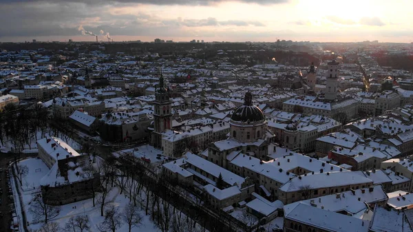 Eski Şehir Lviv 'in kiliseler ve katedrallerle karla kaplı havadan çekilmiş görüntüleri. Kış gün batımı.