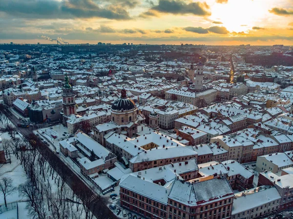 Eski Şehir Lviv 'in kiliseler ve katedrallerle karla kaplı havadan çekilmiş görüntüleri. Kış gün batımı.