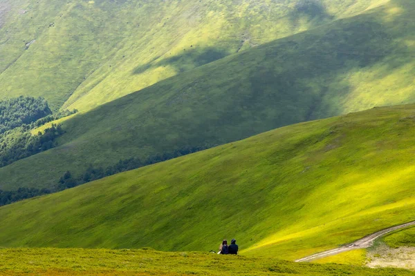 Yeşil Dağlarda Oturan Romantik Çift Sahnesi.