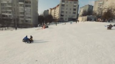 Lviv, Ukrayna - 01.20.2022: FPV Drone Sinematik Çekim: Mutlu çocuklar kaydırak kayarak kayıyor