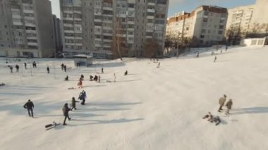Lviv, Ukrayna - 01.20.2022: FPV Drone Sinematik Çekim: Mutlu çocuklar kaydırak kayarak kayıyor
