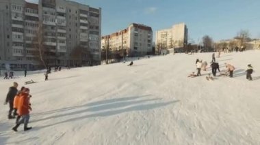 Lviv, Ukrayna - 01.20.2022: FPV Drone Sinematik Çekim: Mutlu çocuklar kaydırak kayarak kayıyor