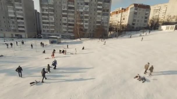 Lviv, Ukraine - 20.01.2022: FPV-Drohnenfilm: Glückliche spielerische Kinder beim Schlittenfahren auf der Rutsche