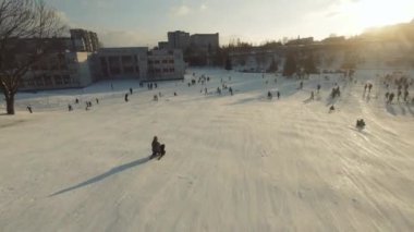 Lviv, Ukrayna - 01.20.2022: FPV Drone Sinematik Çekim: Mutlu çocuklar kayaktan kayıyor. Güneşli gündüz.