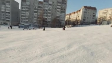 Lviv, Ukrayna - 01.20.2022: FPV Drone Sinematik Çekim: Mutlu çocuklar kayaktan kayıyor. Güneşli gündüz.