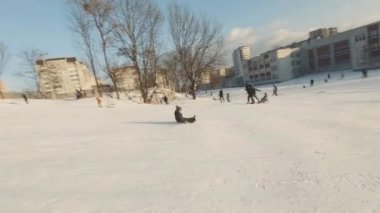 Lviv, Ukrayna - 01.20.2022: FPV Drone Sinematik Çekim: Mutlu çocuklar kayaktan kayıyor. Güneşli gündüz.