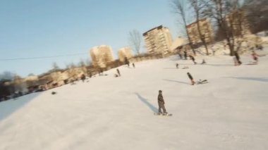 Lviv, Ukrayna - 01.20.2022: FPV Drone Sinematik Çekim: Mutlu çocuklar kayaktan kayıyor. Güneşli gündüz.