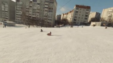 FPV Drone Sinematik Çekimi: Mutlu çocuklar kayaktan kayıyor. Güneşli gündüz.