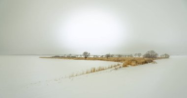 Kış sisi tüm çevreyi kapladı ve karla kaplı tarlaların arasında sonbaharın hâla hakim olduğu küçük bir ada vardı..