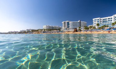 Kıbrıs 'ın güneşli Protaras plajında Akdeniz' in berrak suları