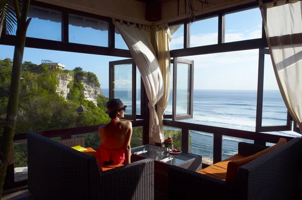 Mujer joven mirando el mar en un café —  Fotos de Stock