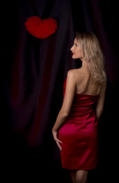 Femme blanche en robe rouge vue du dos avec coeur sur le dos noir — Photo