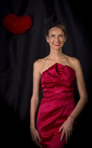 Kobieta w czerwonej sukience z sercem z tyłu czarny — Zdjęcie stockowe
