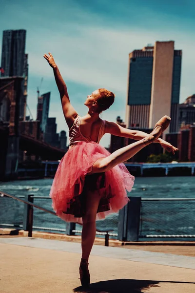 Arka planda şehir manzarasıyla dans eden zarif bir balerin.