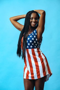 Mutlu Afro-Amerikan modeli mavi arka planda bayrak elbisesi 