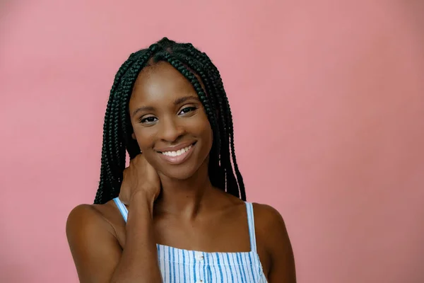 Pembe arka planda poz veren çekici Afrikalı genç modelin portresi. 