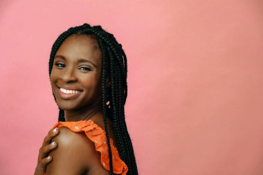 Kameraya gülümseyen Afrikalı Amerikan modelinin portresi.