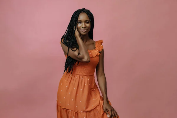 young african american lady in elegant pose on pink background