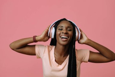 Beautiful young woman dancing and listening music in headphones