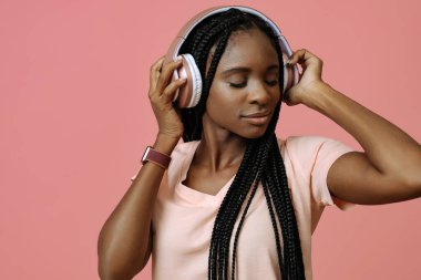 Güzel genç bir kadın kulaklıkla müzik dinliyor.