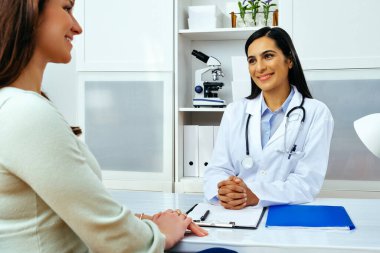 Genç bayan hasta, modern klinik tıp merkezinde hoş bir kadın doktoru ziyaret ediyor.