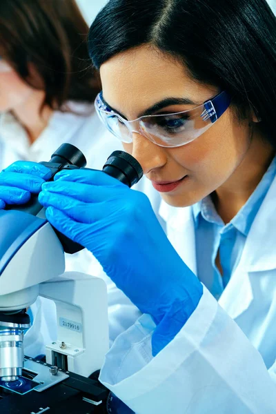 Joven Científica Usando Microscopio Mientras Colega Trabaja Segundo Plano — Foto de Stock